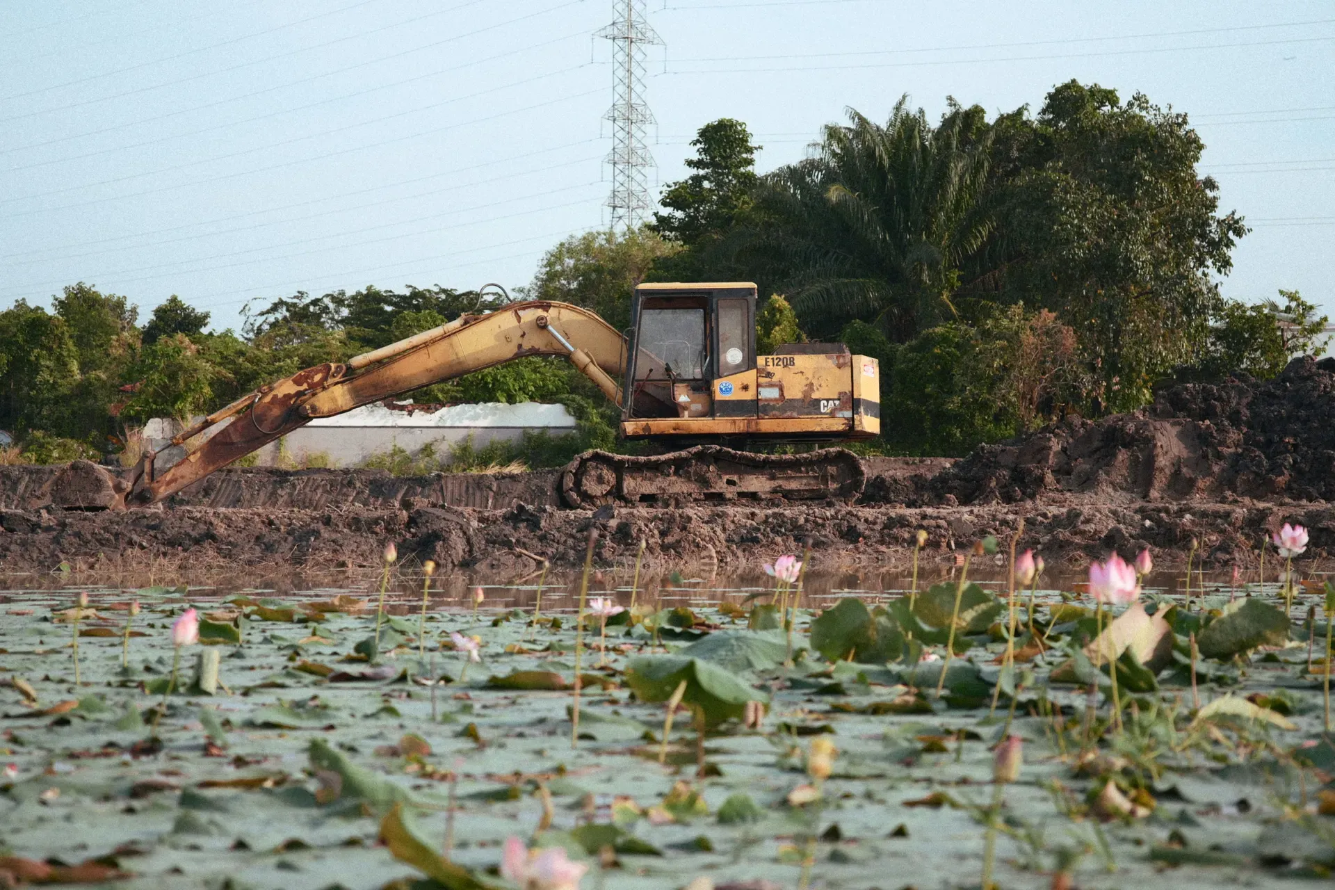 Excavator shaping a pond basin, illustrative of the pond building work a matched contractor performs